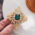 Primo piano di spilla vintage con gemma verde smeraldo, perle e strass luccicanti. - Stile Palazzo Europeo Smeraldo (A19-57)