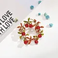 Elegant floral wreath brooch featuring red berries and green enamel leaves in gold finish - Round Berry Wreath (AL669301365390)