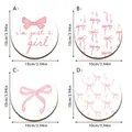 Four pink bow pattern round wooden coasters, 10cm diameter shown with SKU labels - Style SCN306 / Set of 4 (10x10cm)