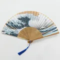 Vue détaillée de l'éventail pliant en bambou avec motif Grande Vague et pompon bleu vif - Style Vague Bambou Top-Gland Bleu