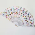 Close-up detail of a white folding fan with colorful sequins and floral embroidery - White Iridescent