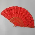 Detailed macro view of a vibrant red sequined folding fan with elegant gold patterns. - Red