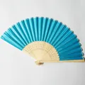 Detailed view of a bright blue silk folding fan with an ornate carved bamboo frame - Lake Blue (No.3)