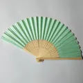 Detail shot of a light green silk folding fan with elegant carved bamboo frame - Emerald Green (No.12)