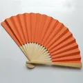 Detailed view of a 9-inch orange blank folding fan with natural bamboo ribs - Orange