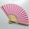A high-quality macro detail view of the 9-inch pink blank folding fan with natural bamboo ribs. - Pink