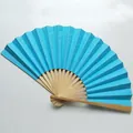 Detailed view of a sky blue 9 inch folding fan featuring natural bamboo ribs for weddings - Lake Blue