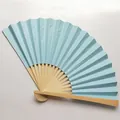 Detail view of a 9-inch candy-colored blue folding fan with natural bamboo ribs. - Light Blue