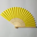 Detailed view of yellow silk folding fan with floral carvings on bamboo frame. - Cauliflower Yellow (No.19)