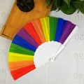 Vibrant rainbow folding fan with white plastic handle on a measurement grid. - 23cm / Plastic Rib Vertical Stripes