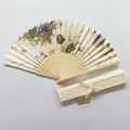 Detailed view of a Japanese floral folding fan with elegant hollow-out gift box. - Gold Floral (IFANS) / Yellow Gift Box Set