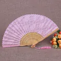 Detalle que muestra el intrincado encaje floral y las varillas de bambú de un abanico rosa. - Costilla Natural Cara Rosa / Rosa