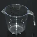 Transparent plastic measuring cup with ergonomic handle and dual-sided measurement scales - 300ml