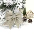 Detailansicht einer glitzernden champagnerfarbenen Weihnachtsschleife in einer festlichen Schneekulisse - 16*17cm (Größe 5) / Champagner