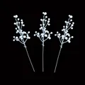 Detail view of three white artificial berry stems for Christmas tree DIY decorations - White
