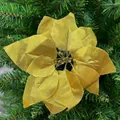 Close-up detail of a decorative golden artificial poinsettia flower on a green Christmas tree - Gold