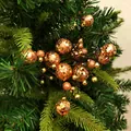 Detailopname van glinsterende oranje kunstbessen op een groene kerstboom versiering - Champagne