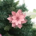 Dettaglio di un fiore di Natale artificiale rosa glitterato su un ramo di pino - Rosa