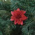 Close-up of a sparkling red artificial Christmas flower on green pine branches. - Red