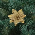 Golden glittery artificial poinsettia flower detail placed on green Christmas tree - Gold
