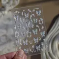 Detail view of holographic butterfly and floral nail art stickers on a transparent sheet - MS1056-Crystal Style