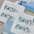 Detailansicht von minzblauen Press-on-Nägeln mit Sternen-, Bären- und Uhrenmotiven - S / Minze Stern Traum - Neu Chinesisch Quadratisch