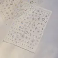 Detailed view of glitter nail stickers with star and heart patterns on transparent film. - to5709 Silver
