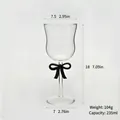 Elegant glass wine goblet featuring a chic black bow tie on the stem with dimensions - Black