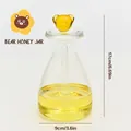 Detail of transparent glass honey jar with cute yellow bear handle lid and stirrer - Large Size (Bear Style)