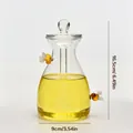Detailed dimension view of clear glass honey jar with bee accents and stirrer lid - Large Size (Two Bees Style)