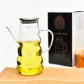 Clear glass oil dispenser bottle with measurement markings and metal lid on a wooden tray - Striped H Style / 800ML