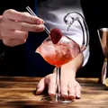 Exquisite detail of a unique swan-shaped glass filled with a red cocktail and ice - Swan Wine Glass