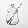 Detailed view of clear glass honey storage jar with ribbed texture and stirrer - Small Honey Pot