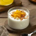 Nahaufnahme einer minimalistischen Glas-Dessertschale mit Joghurt und frischer Mango - Gerader Becher (8*5) / Transparent