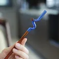 Hand hält einen kreativen blauen und bernsteinfarbenen gebogenen Glasstrohhalm - 波浪双色(K款) / 宝蓝色+琥珀色