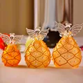 Vista dettagliata di tre figurine di angeli smerigliate semitrasparenti con accenti di perla. - Stile di Decorazione in Perle Giallo Arancio (ts0072)