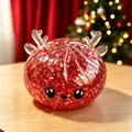 Gros plan d'un jouet squishy de renne de Noël à paillettes rouges avec des bois. - Série de Noël Renne Rouge / Rouge