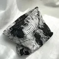 Detail of black and white abstract print cosmetic pouch with zipper and woven text label. - Black White Floral