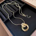 Elegante gouden ketting met geplooide ronde hanger en verfijnde slangenketting - Ketting / Goud