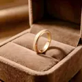 Nahaufnahme eines goldenen drehbaren Edelstahlrings mit mattierter Textur in einer Box - Größe 5 / 4mm / Gold