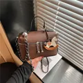 Premium braune Umhängetasche aus genarbtem Leder mit niedlichem Schaukelpferd-Anhänger - Stil mit Anhänger / Kaffeebraun