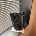 Borsa a secchiello a tracolla in denim casual da donna, borsa minimalista con ricami. - Nero