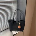 Vue détaillée du sac cabas élégant en cuir PU noir avec un charmant pendentif d'ours. - Avec Pendentif / Noir