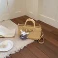 Small yellow textured leather tote bag with cute plush puppy charm and crossbody strap - Yellow With Pendant