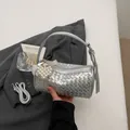 Silver woven cylindrical handbag featuring a pearl heart charm and versatile strap. - Silver With Pendant