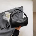 Black woven cylinder shoulder bag, stylish PU leather handbag with zipper and adjustable strap. - Black