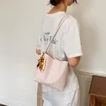 Elegant pink woven shoulder bag featuring a stylish beaded charm in French minimalist style. - Two-Piece Bag Set / Pink With Pendant