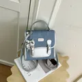 Mochila chic de mezclilla azul para mujer con adornos plateados y colgante de lazo decorativo - Con Colgante / Plateado