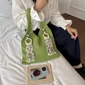 Schicke grüne Strickhandtasche für Damen mit dekorativen Evil Eye Quasten und Holzringen - Grün