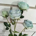 Nahaufnahme Detail eines künstlichen Rosenblütenzweigs mit mehreren Köpfen und grünen Blättern - Canvas-Stoff in Blau